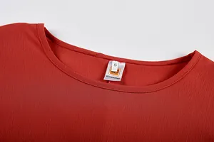 Vista ravvicinata dello scollo rotondo di una maglia a maniche lunghe rosso-arancio