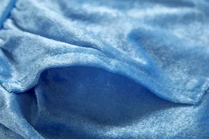 Close-up detail of soft blue velvet fabric showing pocket stitching and texture