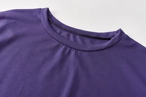Detailaufnahme des verstärkten Rundhalsausschnitts und der lila Stoffstruktur des Sets.