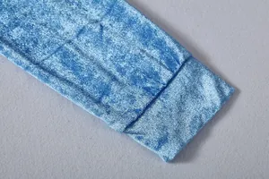 Close-up detail of the soft blue golden velvet fabric texture on the garment sleeve.