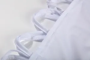 Gedetailleerde close-up van de witte stoffen bandjes en stiksels op een sexy zomerjurk