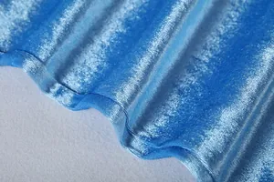 Close-up detail of blue gold velvet fabric showing soft texture and sheen