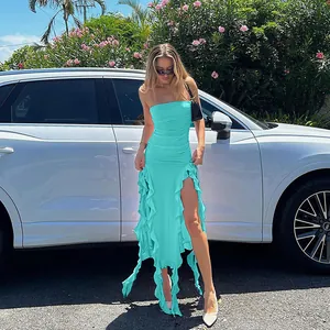 Turquoise strapless bodycon dress with irregular ruffled hem shown in outdoor setting