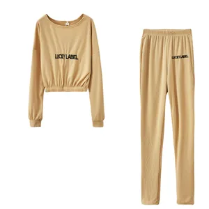 Detailansicht des khakifarbenen Lounge-Sets aus Rippstrick mit Lucky Label-Stickerei.