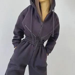 Close-up of black hooded sporty jumpsuit for women with multi-zipper design details.