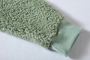 Detalle de puño de canalé verde salvia en la manga de una chaqueta de forro Sherpa
