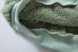 Vista macro detallada del forro polar sherpa verde y del puño acanalado de la chaqueta