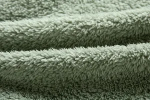 Primer plano de la textura del tejido polar verde de una chaqueta de invierno
