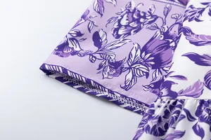 Close-up view of the purple floral print fabric and neat stitching on this elegant dress