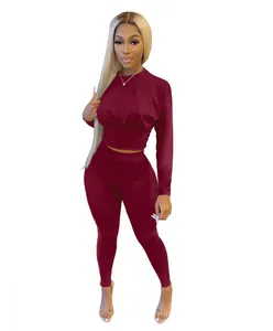Front detail view of women's burgundy two-piece sports set with cinched waist top and leggings