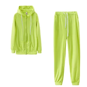 Survêtement de sport deux pièces vert néon avec sweat à capuche et pantalon assorti.