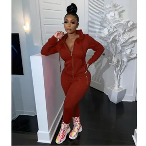 Chic red two-piece tracksuit featuring a zip-up hoodie and pants with zipper pockets