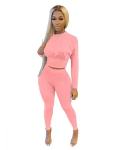 Women's two-piece pink sports set with long-sleeve cinched waist top and leggings