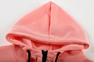 Close-up detail of pink fleece hooded sweatshirt with black drawstring and zipper