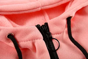 Detailed view of pink hooded jumpsuit featuring black metal zipper and woven drawstring