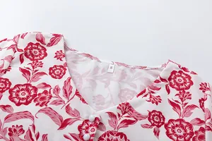 Macro view of V-neckline with white buttons and red floral pattern on summer dress
