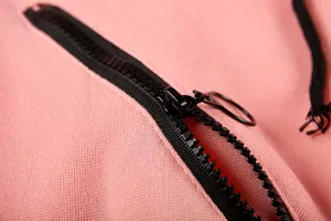 Close-up view of the durable black zipper with a ring puller on a pink jumpsuit fabric