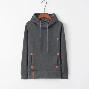Close-up detail of gray hooded sweatshirt with chest embroidery and pocket patches