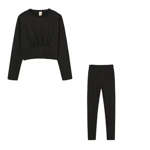 Detail view of black two-piece sports set with cropped cinched waist top and leggings