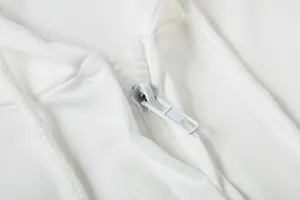 Detailansicht des robusten Reißverschlusses und Kordelzugs an einer weißen Kapuzenjacke