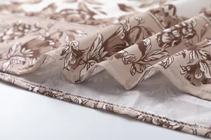 Close-up of the delicate floral pattern and neat stitching on a summer dress hem.