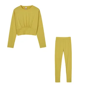 Two-piece yellow activewear set with long-sleeved crop top and matching leggings