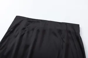 Λεπτομερής κοντινή όψη της μέσης μιας μαύρης σατέν φούστας με κομψές ραμμένες πένσες