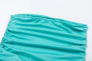 Macro view of the ruched fabric detail on a teal off-the-shoulder bodycon party dress