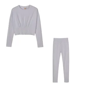 White two-piece athletic set featuring long-sleeved cropped top and matching leggings