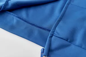 Gros plan d'un sweat à capuche bleu montrant la fermeture éclair et les coutures