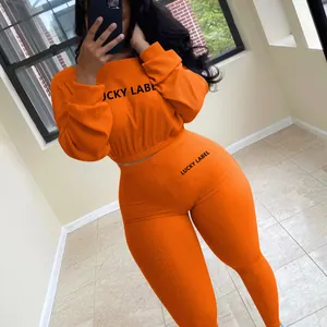 Leuchtend oranges geripptes zweiteiliges Sport-Freizeit-Outfit mit Lucky Label Bestickung