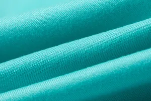 Close-up macro view of soft teal knitted fabric texture with fine weave