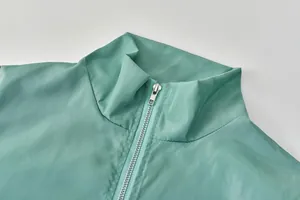 Détail de la veste de sport vert menthe pour femme avec col montant et fermeture éclair