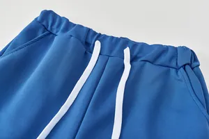 Gros plan sur la taille élastique et le cordon de serrage blanc d'un jogging bleu.