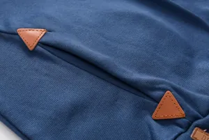 Close-up detail of blue hoodie pocket with brown leather triangular patches