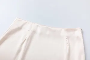 Λεπτομερής κοντινή λήψη της μέσης της σατέν φούστας σαμπάνιας και του πλαϊνού φερμουάρ