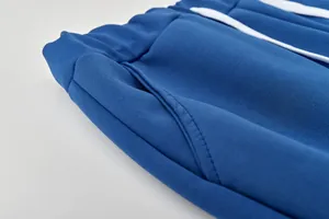 Gros plan sur la poche latérale et la taille élastique d'un pantalon de jogging bleu