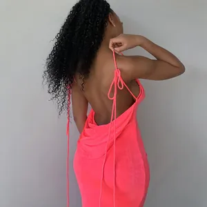 Detail showing the backless design and tie straps of this vibrant neon pink maxi dress.