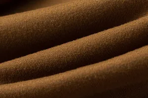Detailed close-up of high-quality brown knitted fabric with soft texture and elegant drape