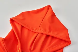 Detailed macro shot of the hood stitching on a vibrant orange women's sports hoodie.