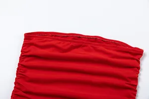 Close-up of the elastic neckline and ruched detail on a red off-the-shoulder dress