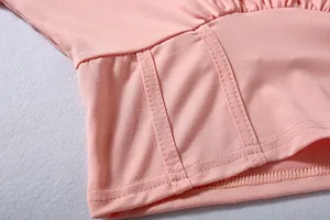 Close-up of pink sports top showing detailed waist stitching and fabric texture
