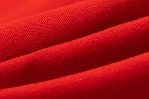 Detailed macro view showing the high quality soft red knitted fabric texture of the dress