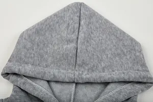 Detailopname van grijze hoodie met capuchon die zachte fleecetextuur en naden toont