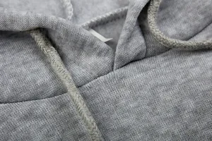 Detailopname van de halslijn van een grijze hoodie met weergave van de stoftextuur en koord