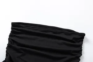 Macro detail view showing the ruched texture of a black off-the-shoulder bodycon dress.