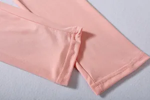 Close-up of pink elastic fabric with durable double-needle stitching detail.