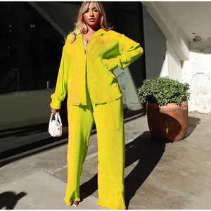 Vibrant neon yellow pleated two-piece set featuring long-sleeve shirt and wide-leg trousers