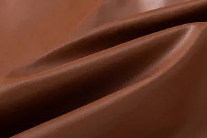 Macro detail of high-quality brown PU leather fabric showing fine grain texture