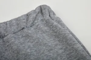 Close-up van de elastische tailleband en grijze gemêleerde stof van de damessweatshirt